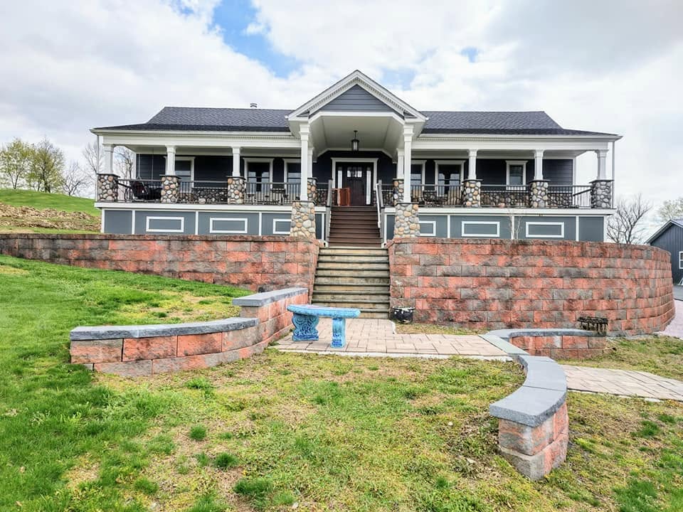 Painted farmhouse exterior with stone accent wall and covered porch